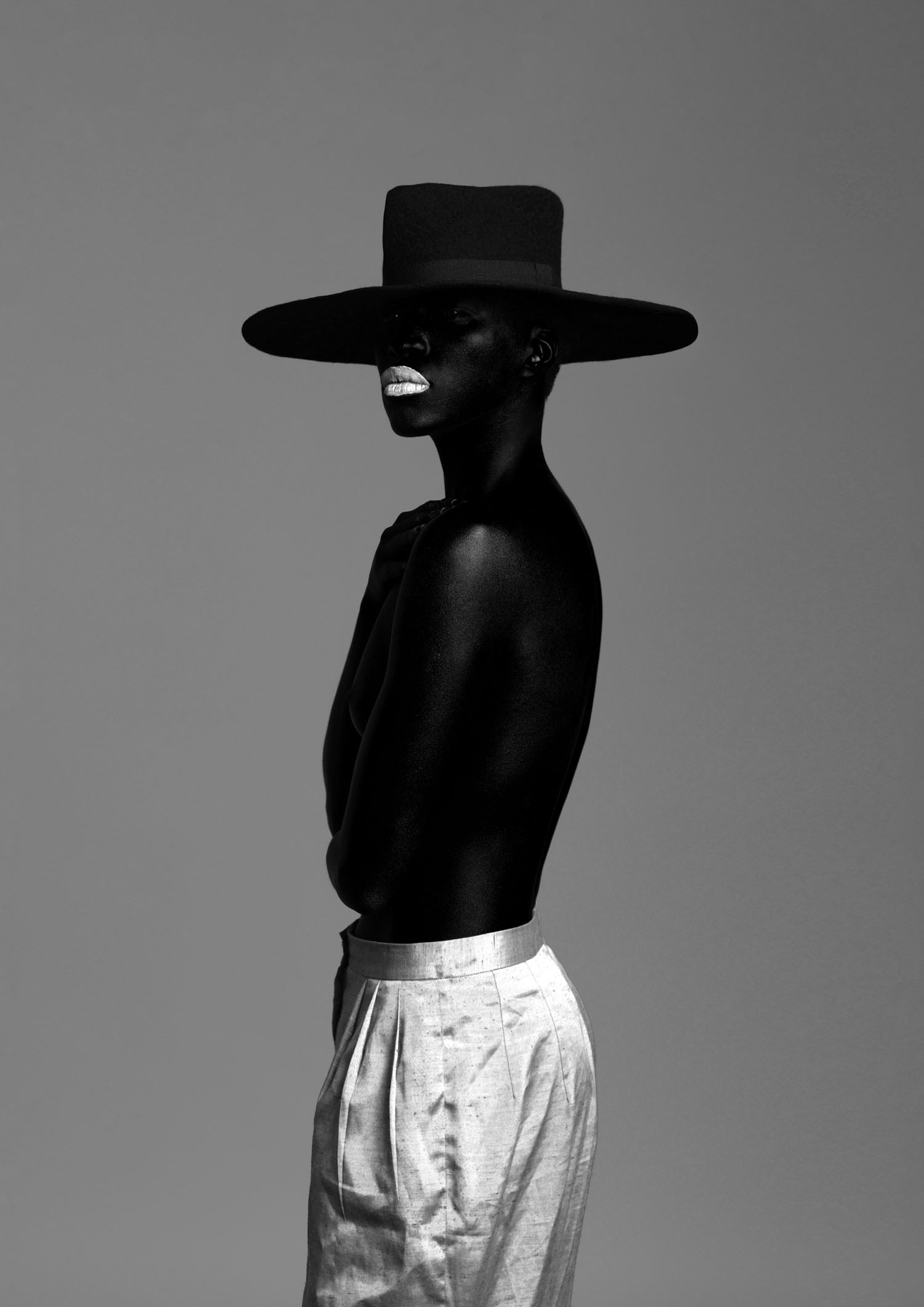 Monochrome profile portrait with an architectural hat
