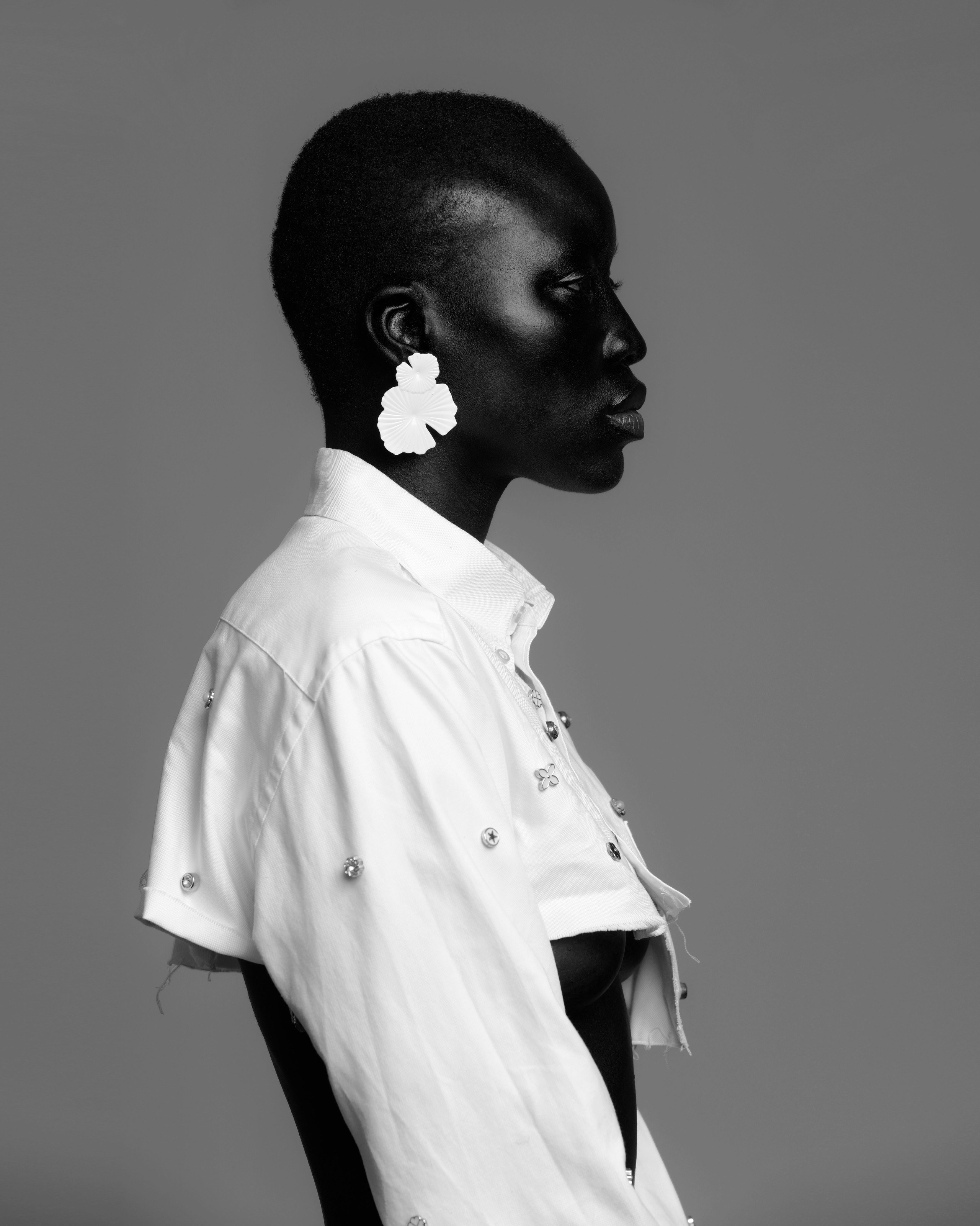 Profile fashion portrait in white with floral earrings